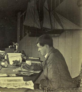 Jack B Yeats sits at his desk working - in front of him, standing on the window sill and looking directly at the camera is his dog HooliganGallery of Ireland's Yeats Archives