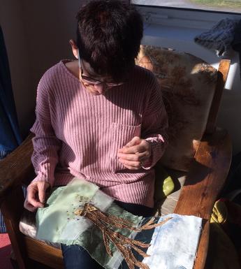 Woman embroidering a tree on fabric