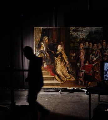Photo of a large painting in a darkened room with silhouette of figure walking past
