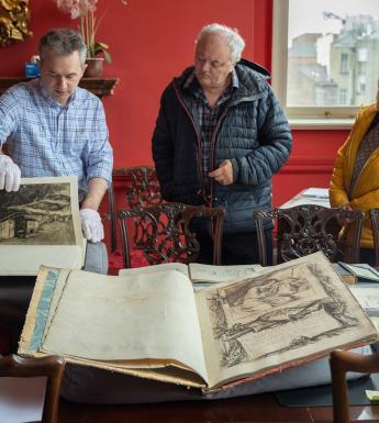 People looking at a display of old, rare illustrated books