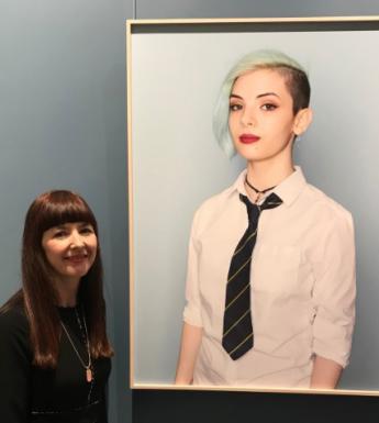 Artist Mandy O'Neill standing next to her portrait of Diane in the National Gallery of Ireland.