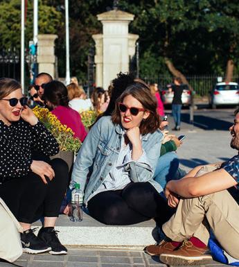 A group of three people sitting on steps and talking