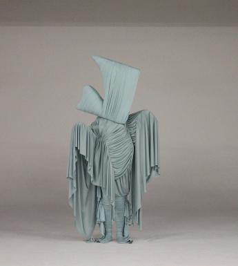 Sculptural textile costume in pale grey draped fabric
