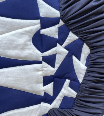 Textile artwork in blue and white with an abstract, geometric pattern