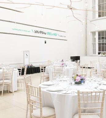Large white room with round white tables and chairs