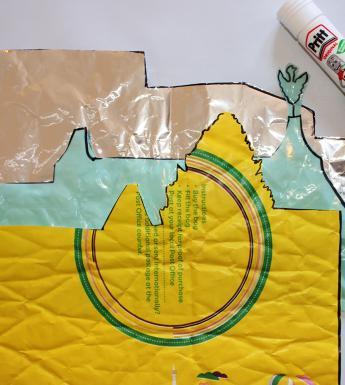 A collage cityscape made with yellow, blue and pink paper, with glue stick and sellotape