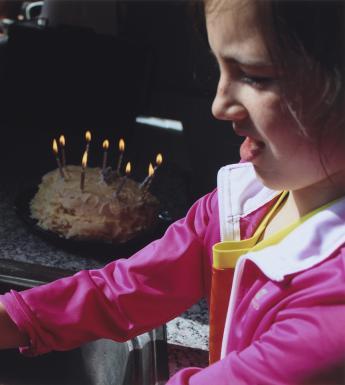Photograph portrait of young girl washing her hands at the kitchen sink