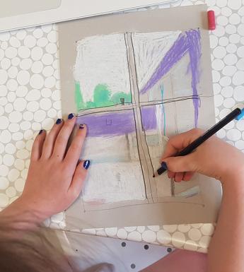 A photograph of a child drawing, taken from above