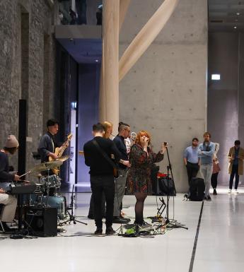A band performing in the courtyard area with a rapt audience looking on