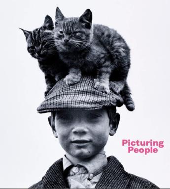 Book cover featuring black and white photo of a boy wearing a tweed cap with two kittens perched on his head