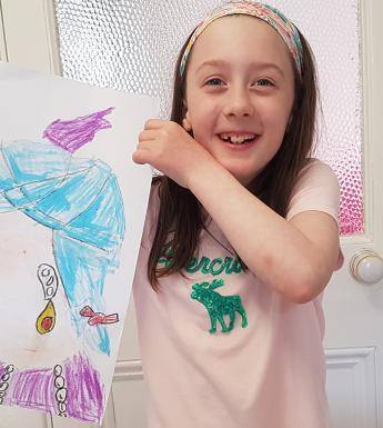 Young girl in a pink t-shirt holding a painting