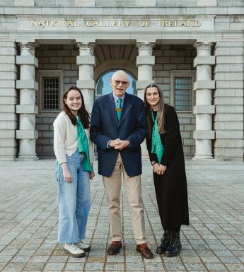 Three people stand on the forecourt of the Gallery, in front of the Merrion Square entrance.