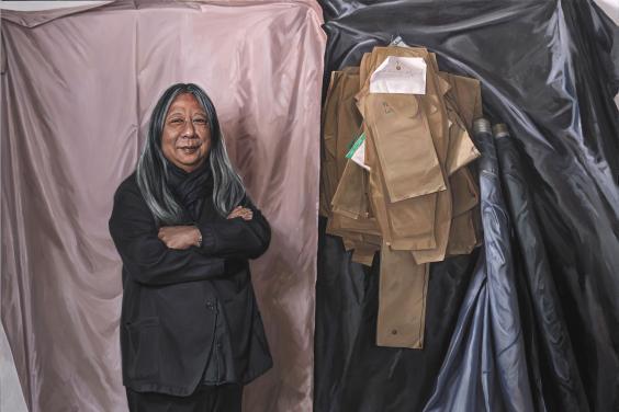 Painted full-length portrait of designer John Rocha wearing all black and standing in front of a wall covered in sheets of fabric and paper patterns.