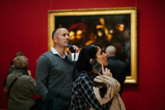 Visitors to Beyond Caravaggio listening to audio guides. © National Gallery of Ireland. 