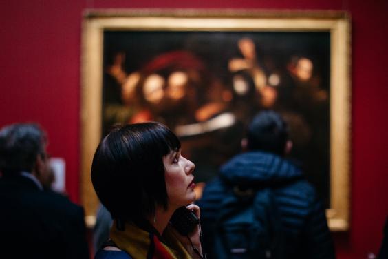 A visitor to Beyond Caravaggio examines a painting. © National Gallery of Ireland. 