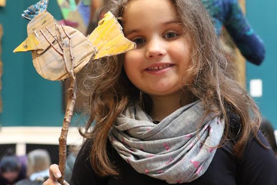 A child holding up her artwork created at a drop-in family workshop in the National Gallery of Ireland.