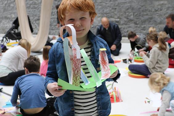 A young boy holds up the artwork he created a drop-in family workshop in the National Gallery of Ireland.