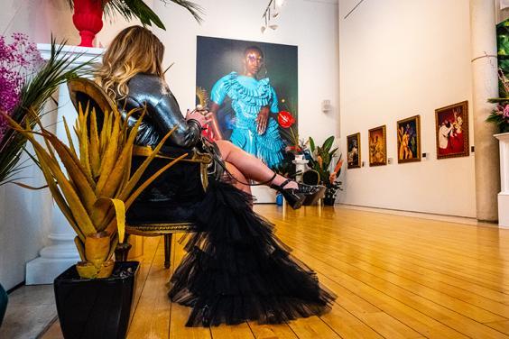 Installation photo of an exhibition with a woman seated in the room