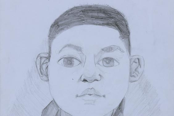 A pencil drawing of a young boy. The boy is facing the viewer directly, and has large eyes, expressive eyebrows, and has his hair cut short. He is wearing a hoodie zipped up to his neck, and we can see the words GAP across his chest.