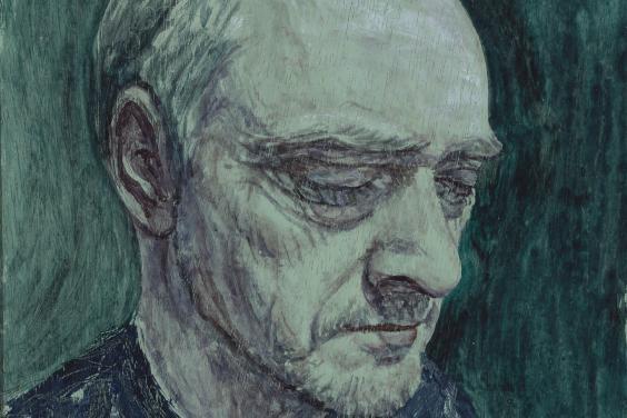 A close-up portrait of a man's face. There is a greenish hue to the portrait, and the man wears a blue jumper. His eyes are closed, and the expression on his face is somber. 