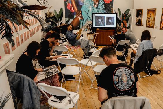 Photo of a group of young people drawing at a portrait workshop