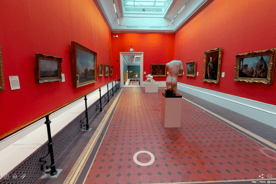 A view of a vibrant red gallery lined with paintings. On the tiled floor stand some sculptures