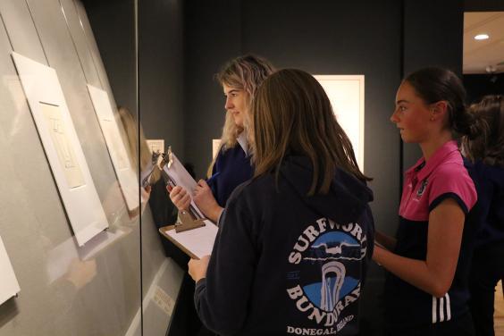 Three teenagers in a print exhibition