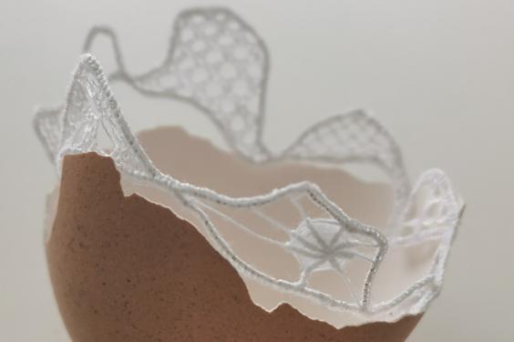 A detail of a work by Fiona Harrington - half an eggshell lined with lace