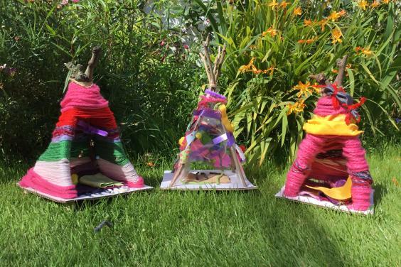 Three homemade mini windshelters in a garden