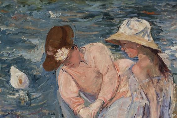 A woman and a child sit in a rowing boat, both wearing summer dresses and hats. The woman is leaning towards the water, looking at the ducks which are swimming near them.