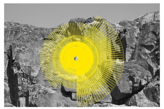 Black and white photograph of a rockface, with a neon yellow spiral graphic in front.