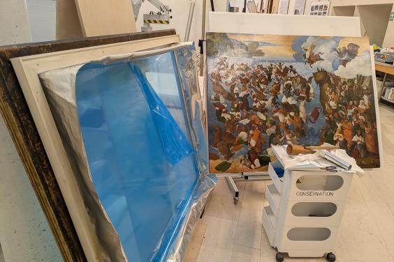 A painting and frame side by side in the conservation studio
