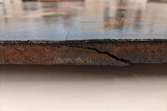 A detail showing a split in the side of a painting