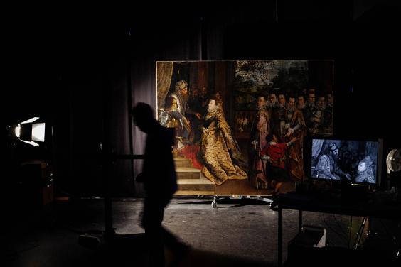 Photo of a large painting in a darkened room with silhouette of figure walking past