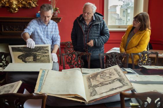 People looking at a display of old, rare illustrated books