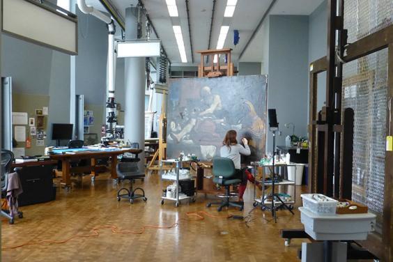 A view of the conservation studio in the Getty Museum with maria Canavan working on Guercino's painting called Jacob Blessing the Sons of Joseph.