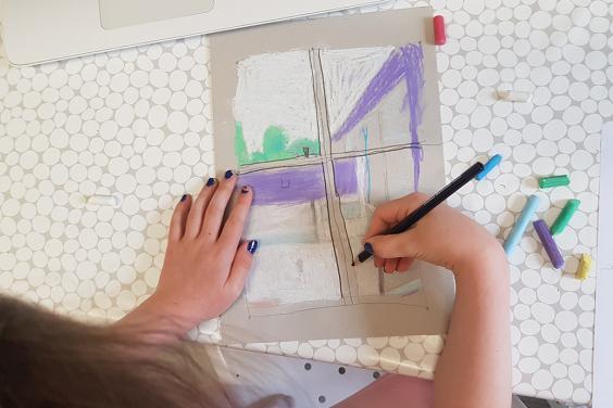 A photograph of a child drawing, taken from above