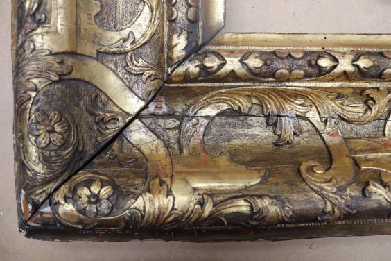 Damaged corner of an ornate gilded frame for a painting