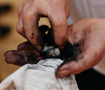 Hands holding charcoal and a cloth