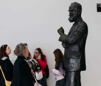 A group of visitors looking at the statue of George Bernard Shaw in the Millennium Wing. © National Gallery of Ireland.