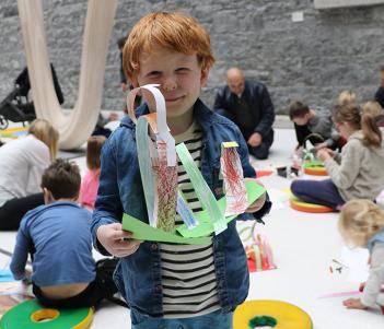 A young boy holds up the artwork he created a drop-in family workshop in the National Gallery of Ireland.