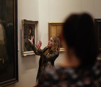 A tour guide speaking speaking about a painting