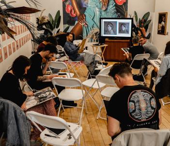 Photo of a group of young people drawing at a portrait workshop