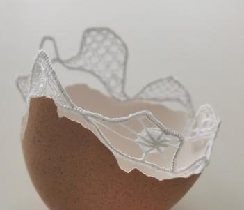 A detail of a work by Fiona Harrington - half an eggshell lined with lace