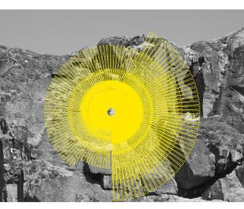 Black and white photograph of a rockface, with a neon yellow spiral graphic in front.