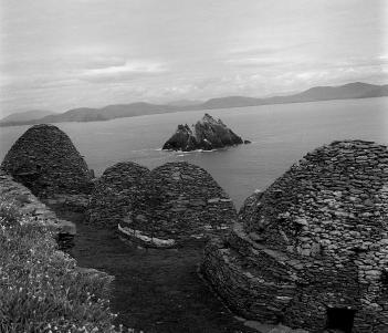 Black and white photograph of the beehive shaped stone huts on top of Skellig Michael