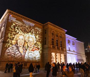 Merrion Square facade of the National Gallery of Ireland building with a portrait of two smiling people projected on to the facade 