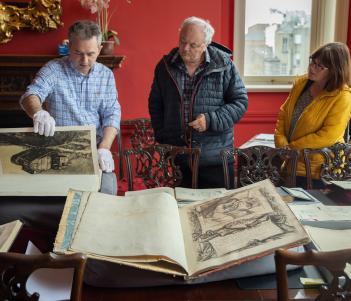 People looking at a display of old, rare illustrated books