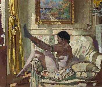 A woman sits on an armchair, naked, in a beam of sunlight, and puts on a stocking.