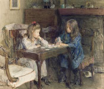 Two young girls sit at a small table building with playing cards.